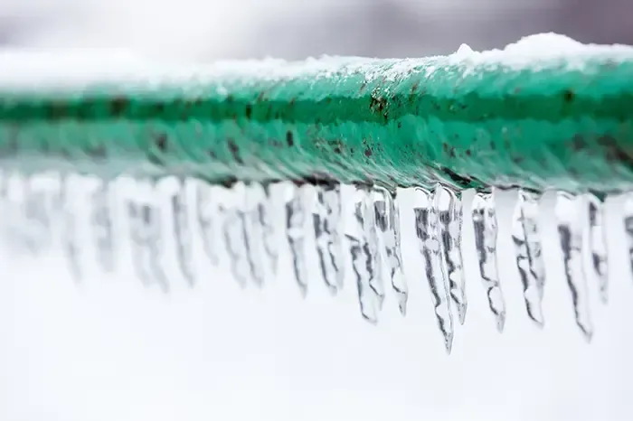 Ice hanging from a frozen pipe during a hard freeze