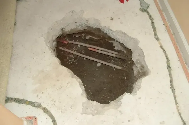 Copper water lines exposed in an opened section of concrete slab