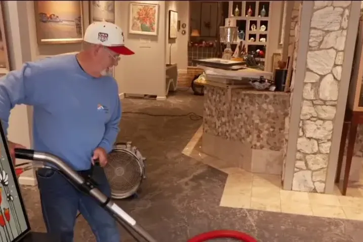 A wet vacuum pulling storm water off a floor inside a home
